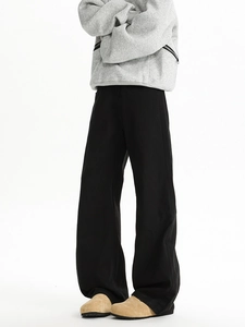 Detail view of black straight-leg casual trousers featuring structured cotton fabric and clean fit