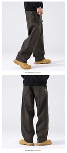 Detail of loose-fit brown cargo pants with large side pockets and durable cotton fabric