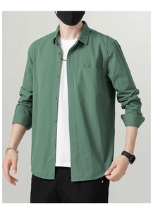Detail view of a men's dark green cotton shirt with front pocket and button closure