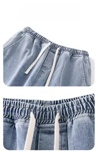 Détail d'un jean bleu clair avec taille élastique et cordon de serrage en coton blanc