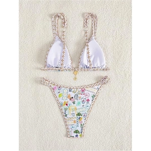 Chic two-piece bikini featuring white chain-strap top and mediterranean floral print bottoms