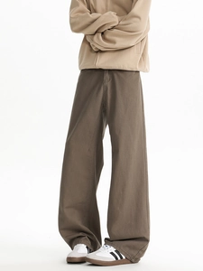 Detailed view of brown wide-leg twill trousers showing relaxed fit and high quality fabric