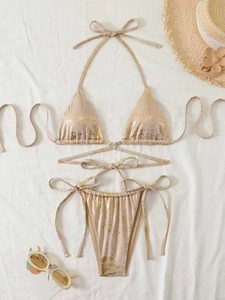 Detail eines champagnergoldenen Bikinis mit Metallfolientextur auf weißem Hintergrund