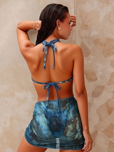 Three-piece blue tie-dye bikini set with halter top and matching sheer sarong cover-up