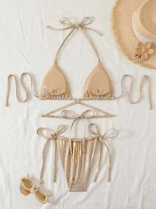 Flachbild-Detail eines goldenen Folien-Bikini-Sets mit strukturiertem Stoff und Urlaub-Deko