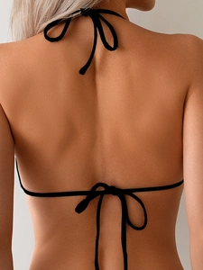 Détail d'un haut de bikini licou noir avec des liens réglables dans le dos et au cou
