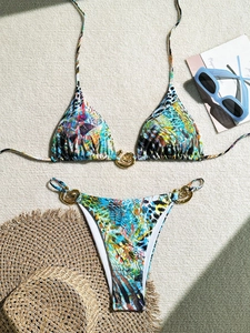 Détail macro du bikini géométrique coloré avec des anneaux métalliques dorés en spirale