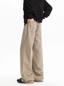 Detail view of khaki flared trousers with large back pockets in a minimalist street style