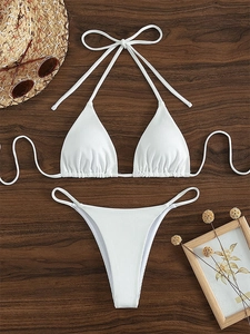 White ribbed halter bikini set with triangle top and tie bottoms on wooden background