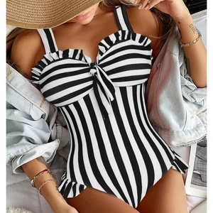 Close-up of black and white striped swimsuit featuring ruffled neckline and bow tie detail
