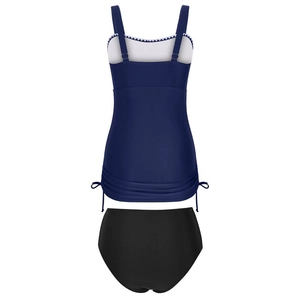 Detail of dark blue tankini top with white scalloped trim and side drawstring design