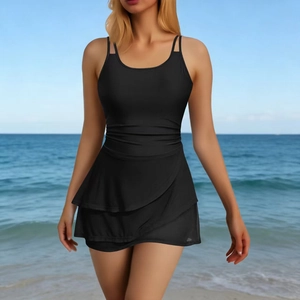 Detail of black one-piece swimsuit featuring side ruching and ruffled skirt hem for women