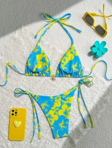 Detail of floral printed bikini with a gold hibiscus charm and side tie strings