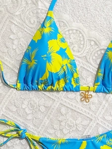 Detail of tropical floral bikini with a golden flower charm and side tie strings