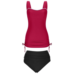 Detail of red tankini top with white scalloped trim and high-waisted black bikini bottoms