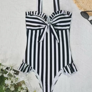 Detail of striped one-piece swimsuit with bow tie, ruffles and halter neck design