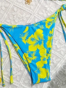 Detailed view of high-cut floral bikini bottom with adjustable bright yellow side ties