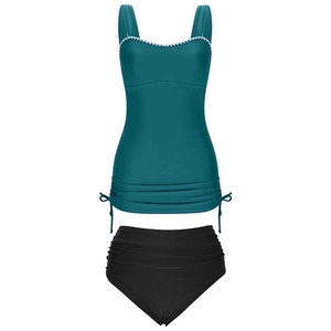 Detail of dark green tankini top with white scalloped trim and black high-waisted bottoms