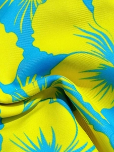 Detailed macro view of yellow and blue floral print on high-quality swimwear fabric