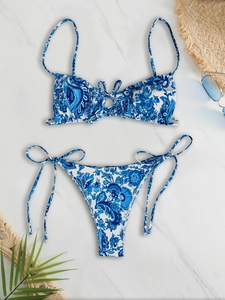 Blue and white paisley print bikini set with side-tie bottoms on marble surface