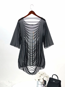 Detail of black sheer mesh beach cover-up with stylish cutout back design on a hanger