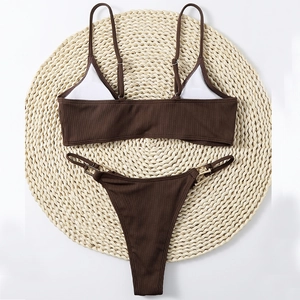 Flat lay of brown ribbed bikini set with adjustable straps and gold buckle accents