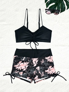 Bikini due pezzi con top a coulisse nero e slip a fiori rosa e bianchi per donna