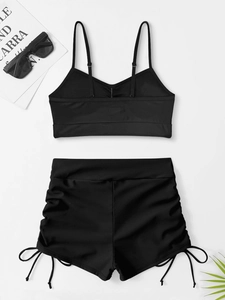 Flat lay of black two-piece bikini with adjustable drawstrings and high waist shorts