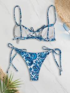 Blue paisley floral bikini set with adjustable tie straps on white marble background