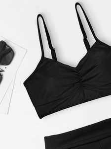 Detail of adjustable straps and gathered bust design on a solid color bikini top