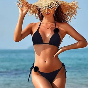 Dettaglio dell'ornamento floreale 3D in tessuto su un bikini nero a triangolo