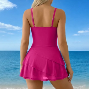 Back view of a rose red one-piece swimdress with adjustable straps at a beach
