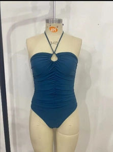 Detail of dark blue halter swimsuit with ring cutout and side ruched waist texture