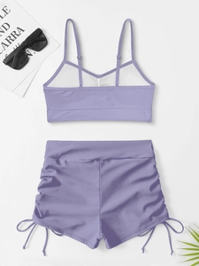Flat lay of purple two-piece bikini with adjustable straps and side drawstring shorts