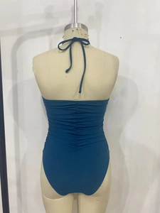 Detail view of the ruched back design on a dark teal one-piece halter swimsuit