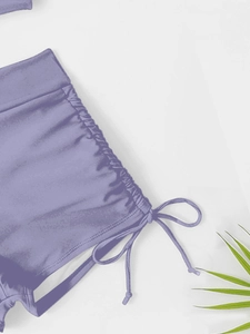 Detail of lavender purple bikini bottom with adjustable side drawstrings and ruched fabric
