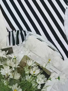 Striped one-piece swimsuit featuring chic ruffles and slimming black and white pattern