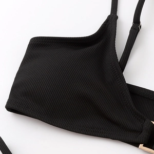 Detail of black ribbed bikini top with adjustable straps and gold metal buckle