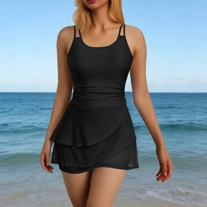 Elegant black one-piece swimsuit with double straps and ruffled skirt on a sunny beach