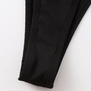 Detailed macro view of black ribbed fabric and double-needle stitching on bikini edges