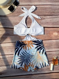 Two-piece halter bikini set with white padded top and tropical leaf print swim shorts