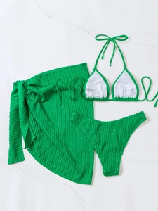 Detail view of a bright green three-piece bikini set with a matching mesh sarong wrap skirt