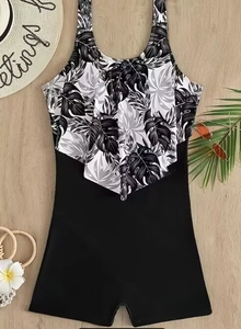 Detail of ruffled black and white leaf print swimsuit with sunglasses and sunhat