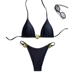 Detail of black shimmer bikini set with gold metal hardware and summer sunglasses