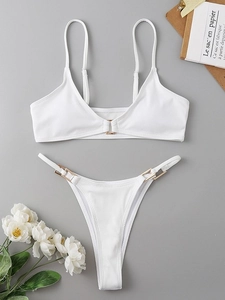 White ribbed two-piece bikini set with thin straps and decorative gold metal buckles
