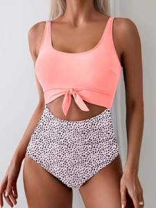 Detail of cutout monokini featuring a front knot and polka dot print on high waist bottom