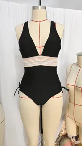 Détail d'un maillot de bain noir avec bande de taille au crochet colorée et liens