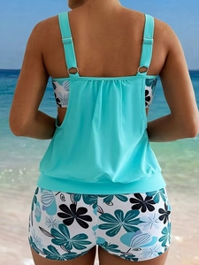 Mint green tankini set with adjustable straps and floral print shorts on beach scenery