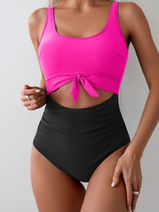 Detail of high waist cutout swimsuit with front knot and vibrant pink and black contrast