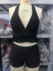 Détail du bikini noir avec bordures à volants et lanières croisées sur un mannequin 34B